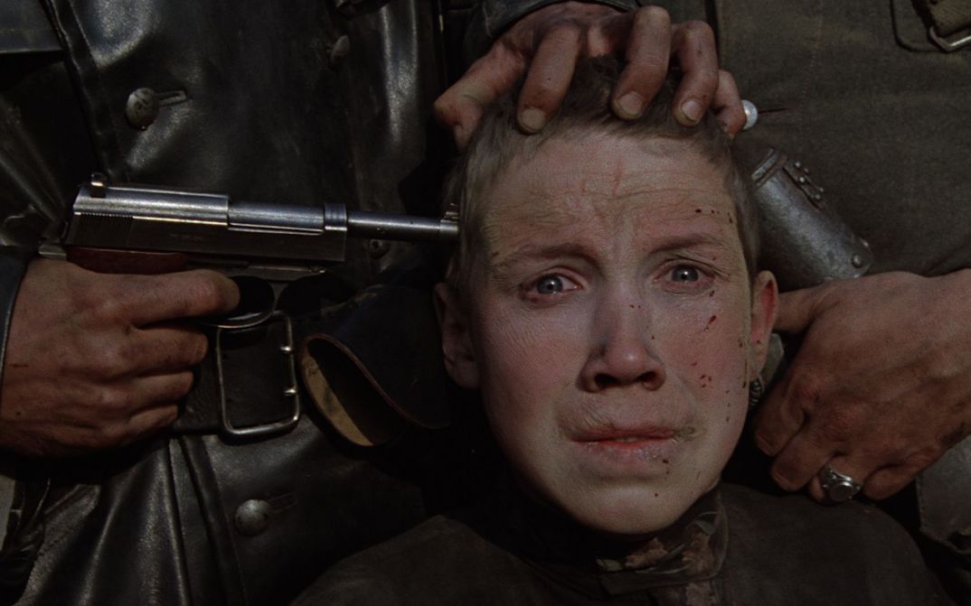 Film still from IDI I SMOTRI: You see the fear-distorted face of a boy with a pistol held to his temple.