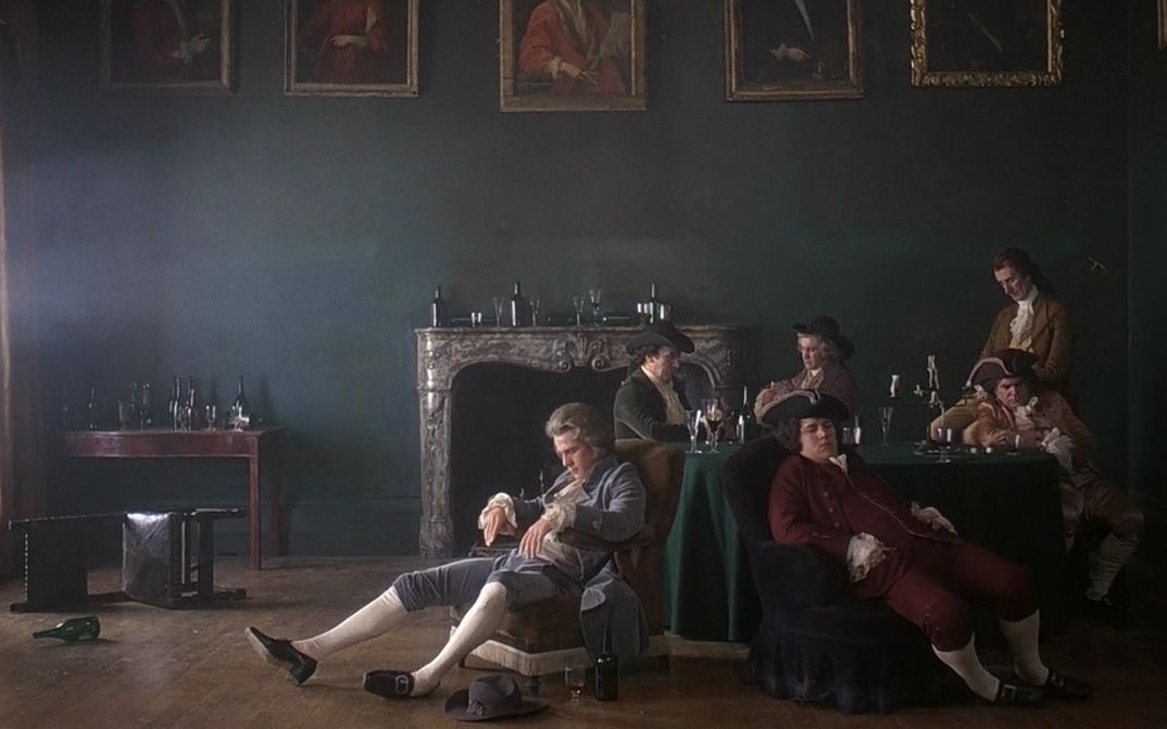 Film still from BARRY LYNDON: Some men in 18th century costumes are sitting around a table, asleep. Empty wine bottles are everywhere. The picture looks like a painting.