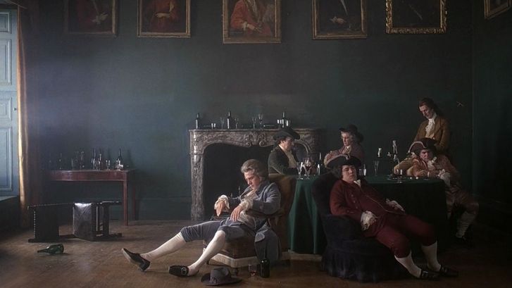 Film still from BARRY LYNDON: Some men in 18th century costumes are sitting around a table, asleep. Empty wine bottles are everywhere. The picture looks like a painting.
