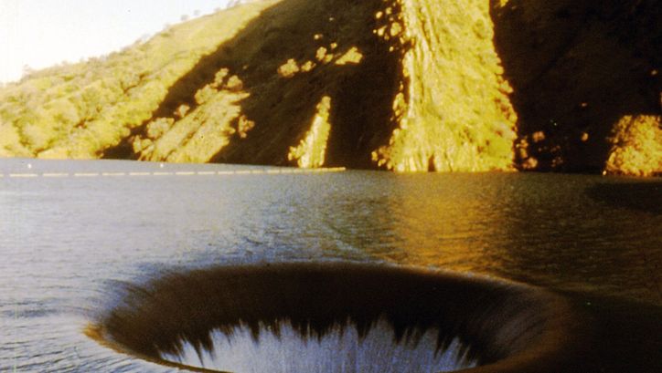 Film still from EL VALLEY CENTRO: You can see a lake with a waterhole.
