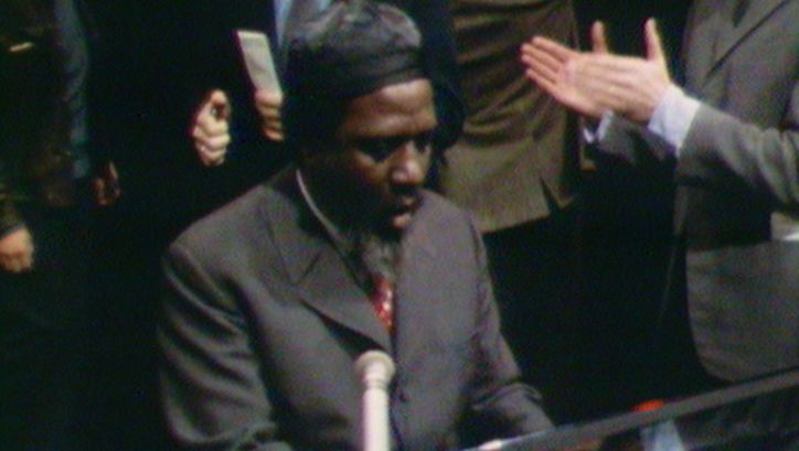 Film still from REWIND AND PLAY: Thelonious Monk is playing the piano. In the background you can see applauding people.