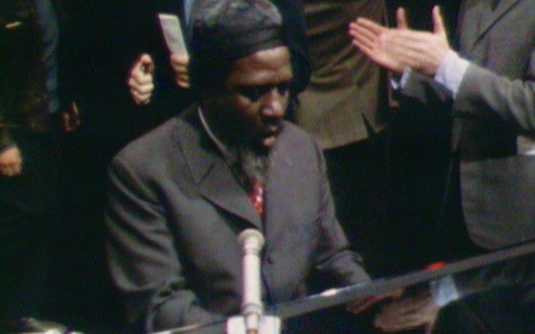 Filmstill aus REWIND AND PLAY: Thelonious Monk spielt Klavier. Im Hintergrund sieht man applaudierende Menschen.