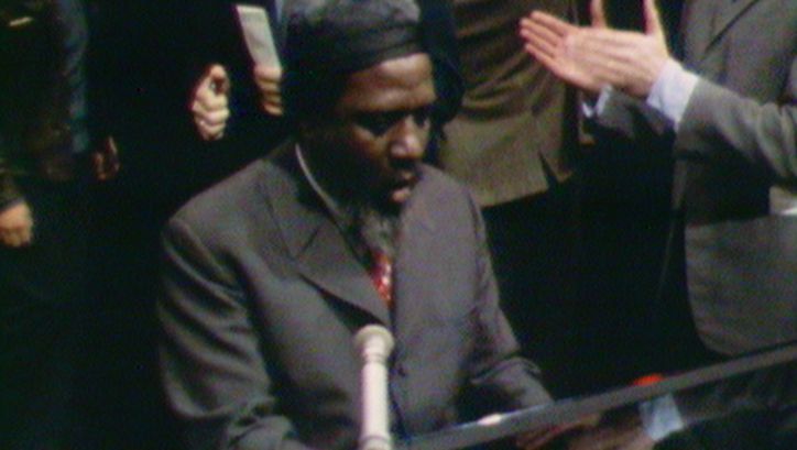 Filmstill aus REWIND AND PLAY: Thelonious Monk spielt Klavier. Im Hintergrund sieht man applaudierende Menschen.