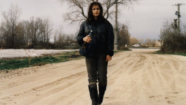 Film still from SANS TOIT NI LOI. A young woman is walking down a street.