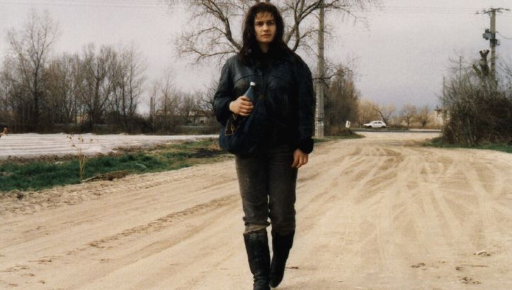 Film still from SANS TOIT NI LOI. A young woman is walking down a street.
