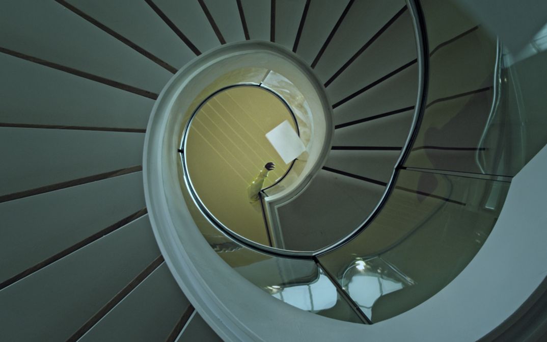 Still from the film "Voices and Shells" by Maya Schweizer. A spiral staircase from above.