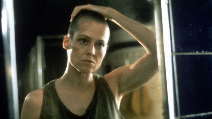 Filmstill aus ALIEN. Sigourney Weaver als Lieutenant Ripley blickt in einen Spiegel.