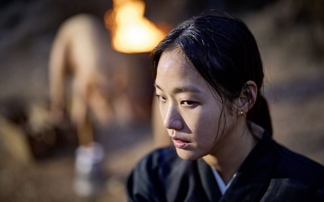Filmstill aus "Pa-myo" von Jang Jae-hyun. Zu sehen ist eine Nahaufnahme einer Frau mit zusammengebundenem Haar und Ohrsteckern.
