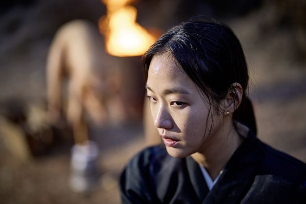 Film still from "Pa-myo" by Jang Jae-hyun. It shows a close-up of a woman with her hair tied back and ear studs. 