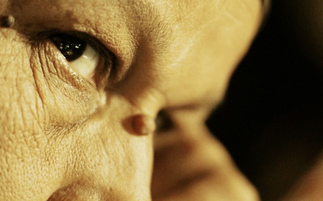 Filmstill aus „Anqa" von Helin Çelik. Nahaufnahme von einem Frauengesicht in einem warmen Licht.