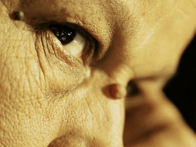 Filmstill aus „Anqa" von Helin Çelik. Nahaufnahme von einem Frauengesicht in einem warmen Licht.