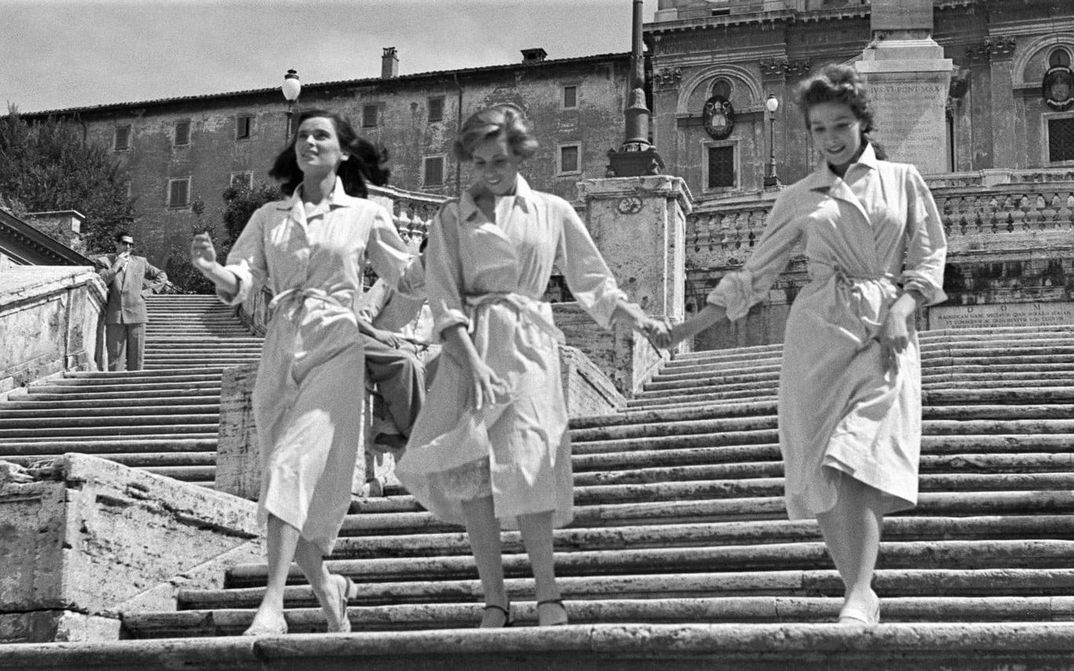Film still from LE RAGAZZE DI PIAZZA DI SPAGNA. Three young women walk together down the steps of the Spanish Steps in Rome.