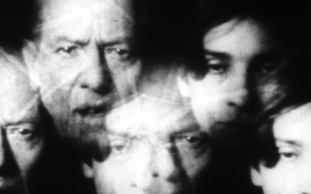 Film still from INFLATION: A collage of several heads.