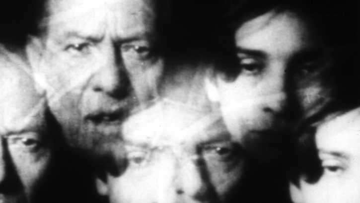 Film still from INFLATION: A collage of several heads.