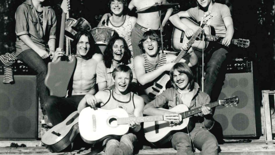 Filmstill aus PATSANY: Eine Gruppe von Jugendlichen mit Gitarren und einem Schlagzeug lacht in die Kamera.